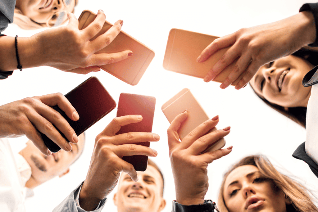 group of teenagers holding smartphones