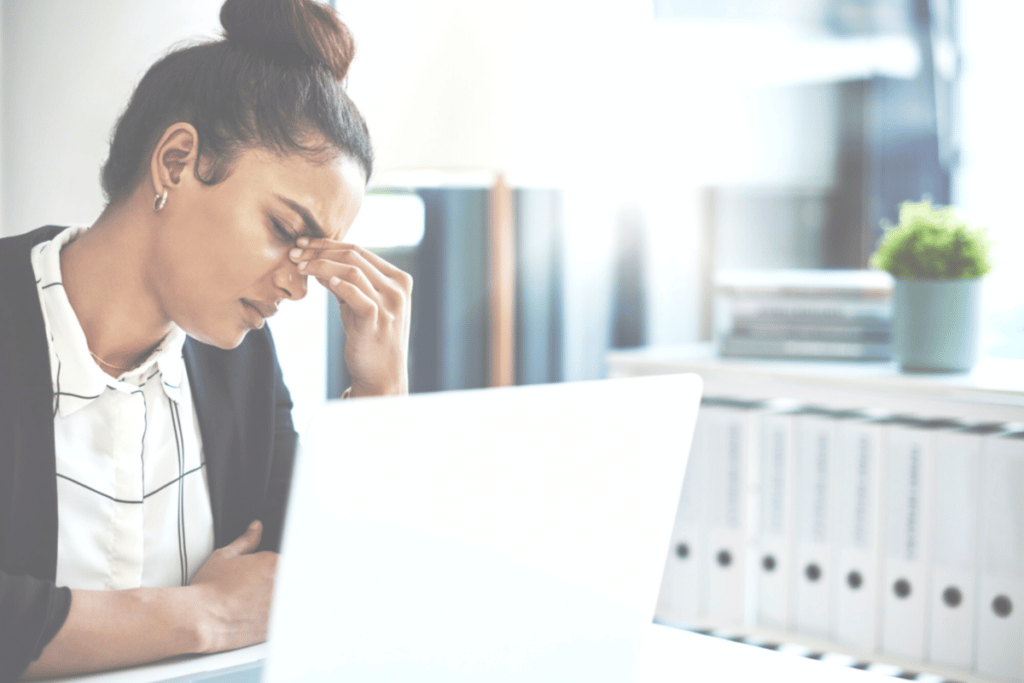 stressed woman pinching her nose between her eyes