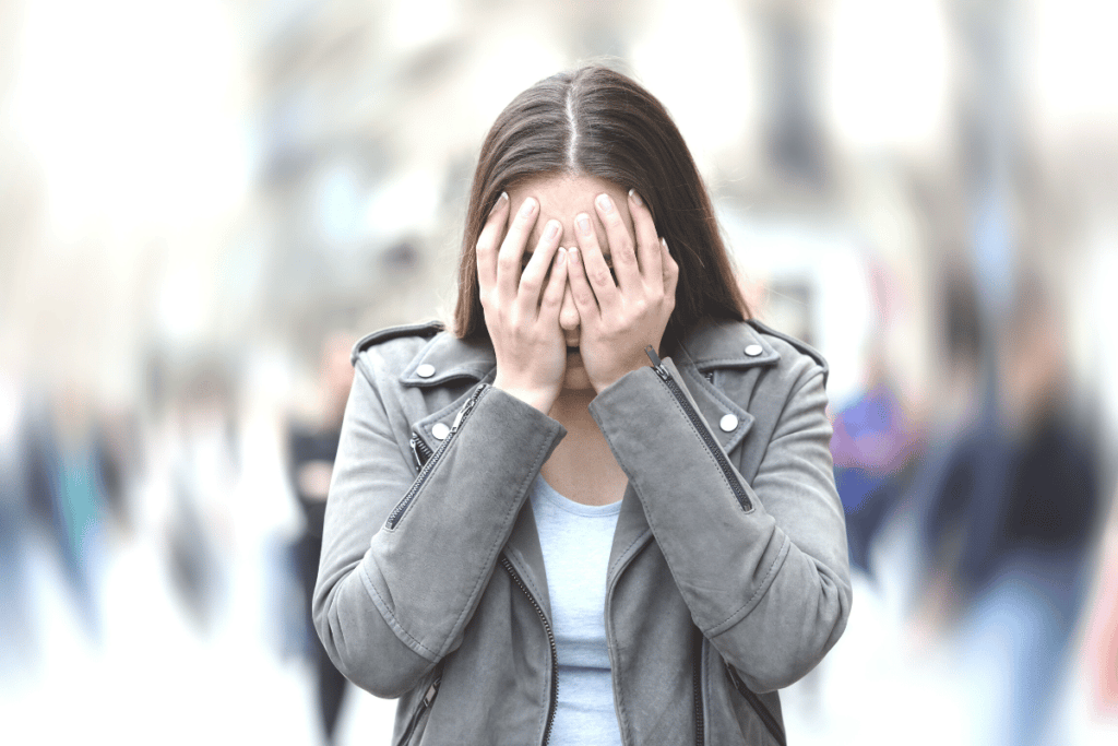 woman covering her face with two hands