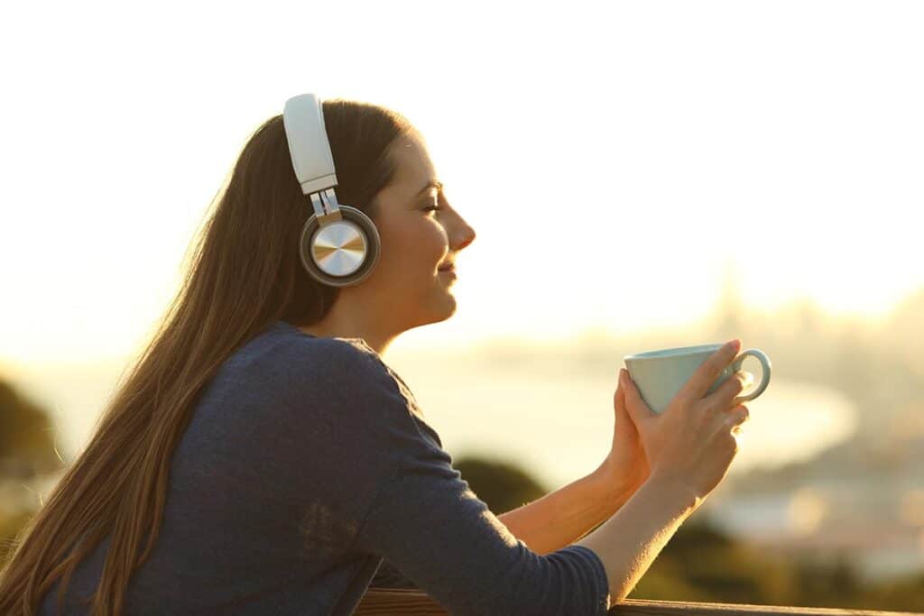 woman enjoying coffee with headphones on showing connection between Music and Mental Health