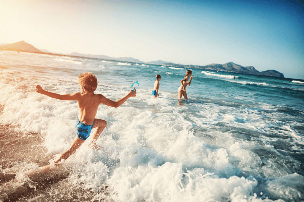 mom playing with two kids on the beach