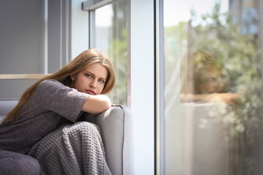 woman resting on couch next to window wondering about common mental health disorders