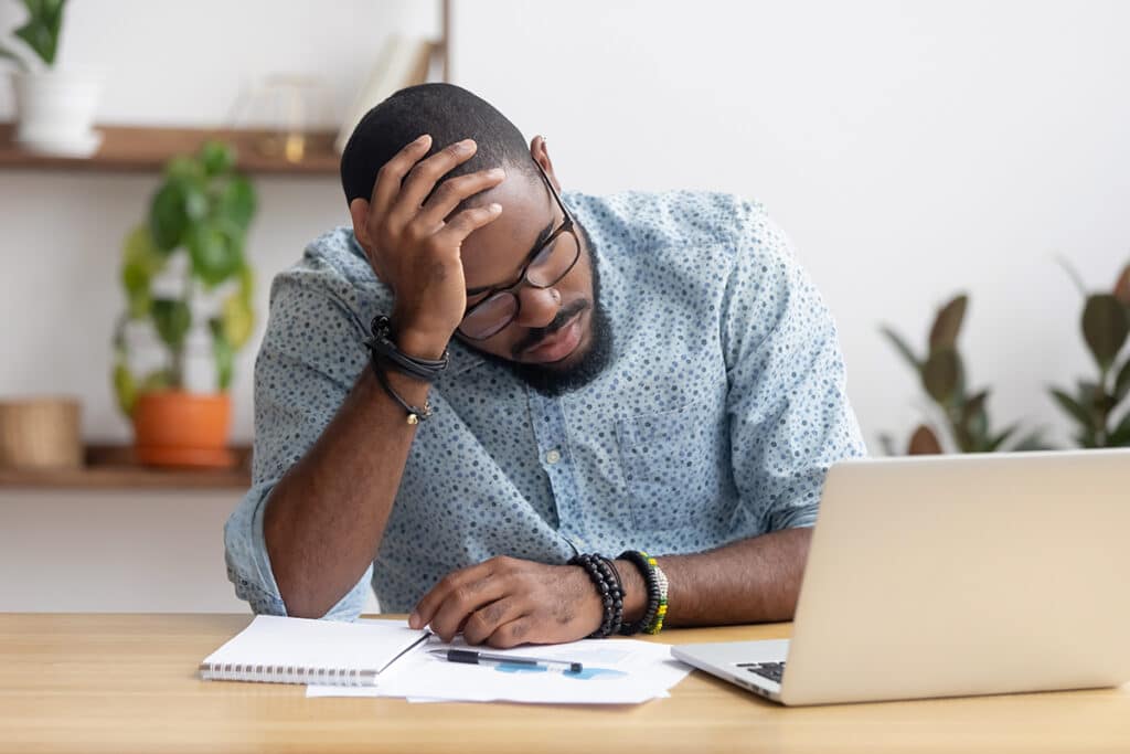 man researching at computer frustrated coping with job loss