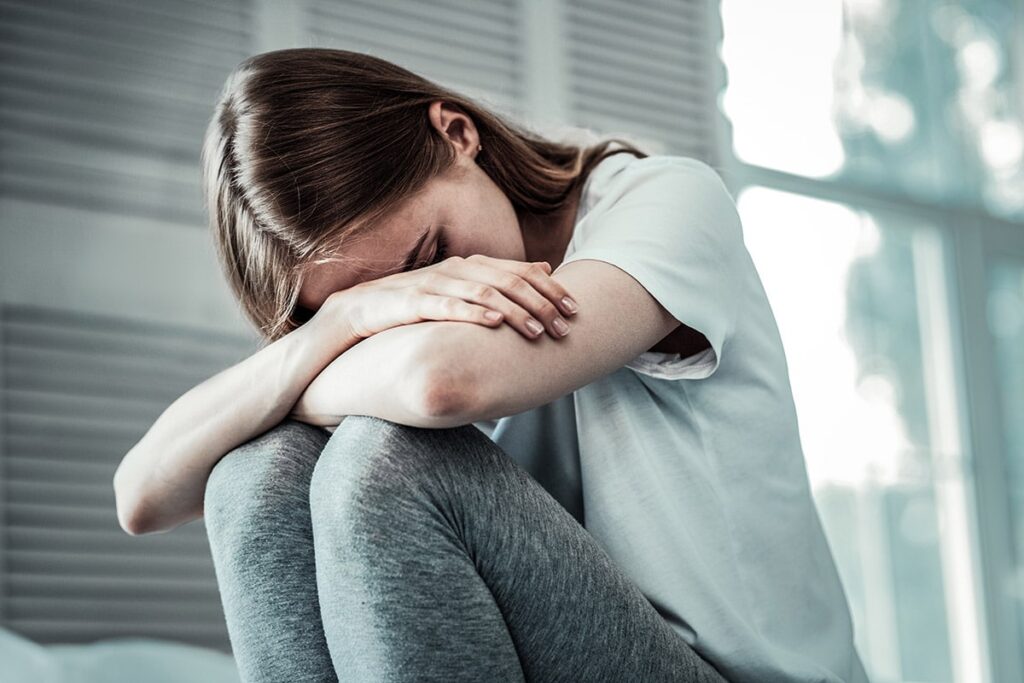 woman sitting in fetal position not knowing the difference between depression and anxiety