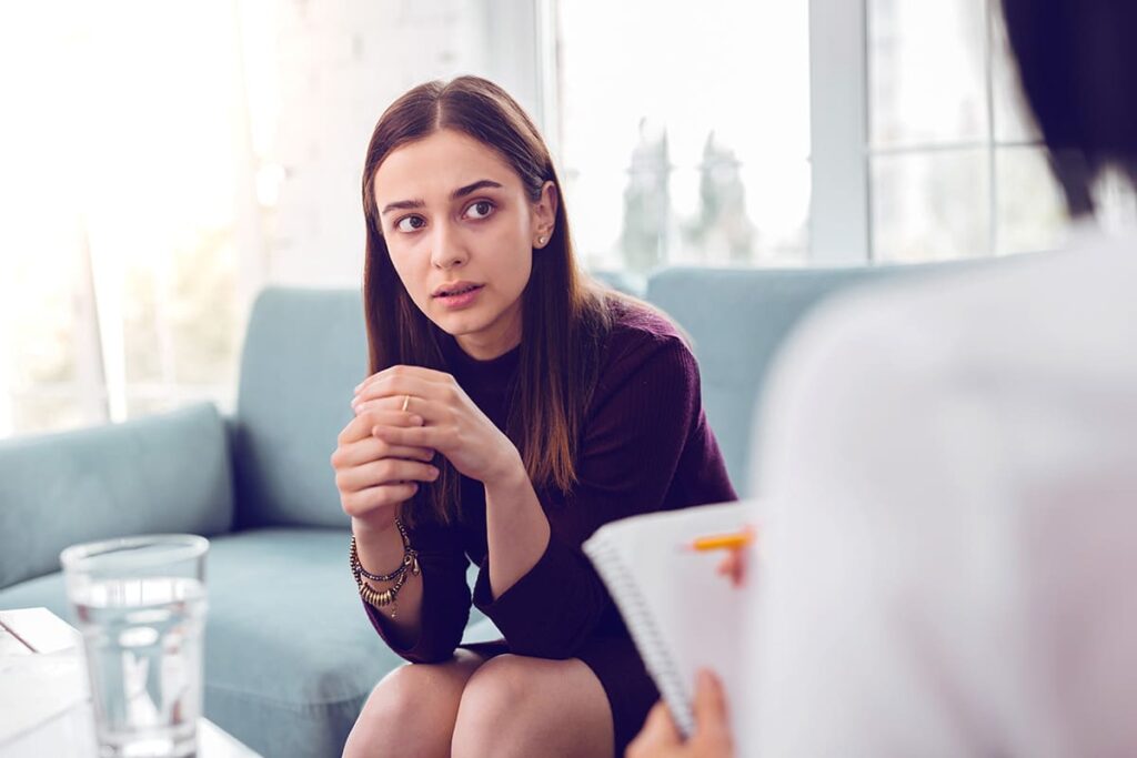 A young woman talks to a friend about how to find a therapist