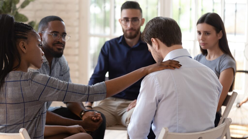 Rear view at upset man feel depression get psychological support from other people