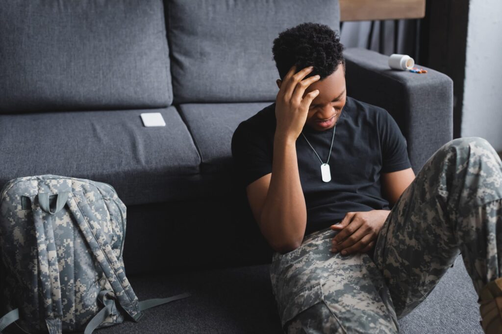 stressed african american soldier sitting on a floor