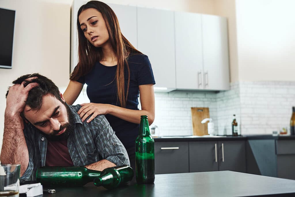 woman comforting man wondering is my loved one an alcoholic