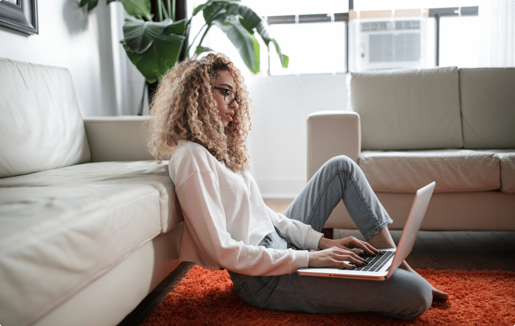 woman sitting on the floor working on a laptop